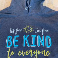 Close up image of the design on our It's Fine, I'm Fine, Be Kind to Everyone® Lightweight Hooded Sweatshirt.