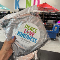 Jackie, at the Shirt Shop, holding our packaged, Peace, Love, and Kindness for Everyone magnet.