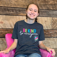 Jordyn, sitting in a pink chair, wearing a small "Original Jordyn" Be Kind to Everyone® shirt.