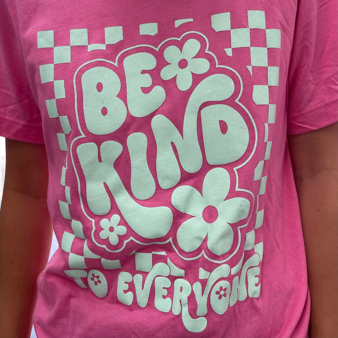 Zoomed in image of our Adult Pink Retro Checkerboard Be Kind to Everyone® Tee