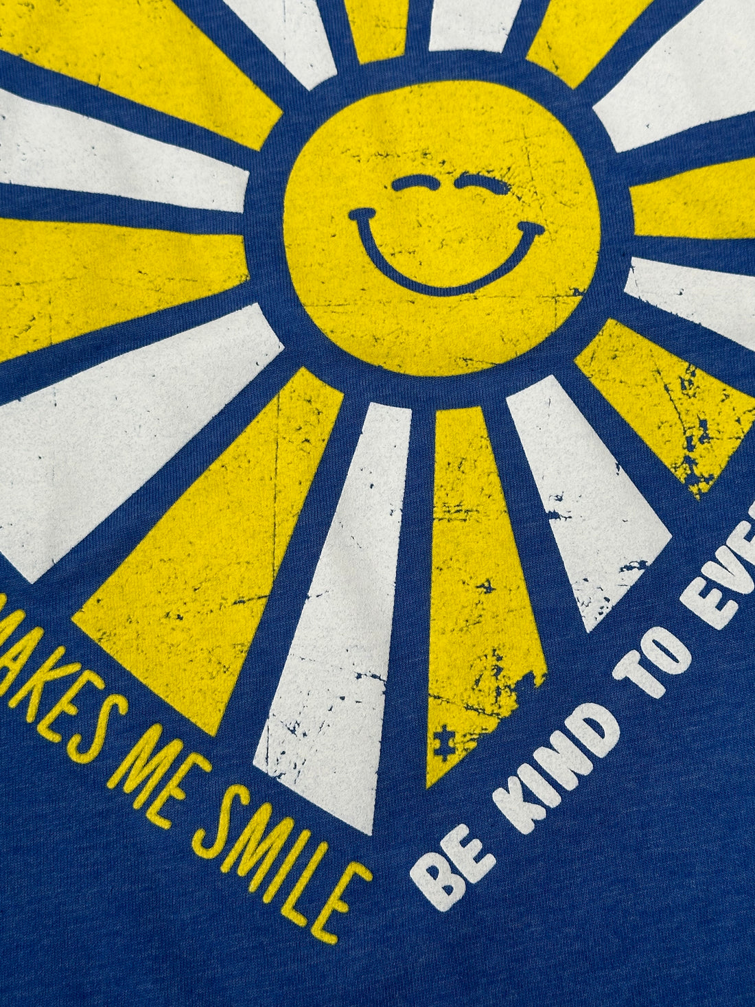 Our Someone with Autism Makes Me Smile Be Kind to Everyone® tee features a puzzle piece in one of the sunbeams.