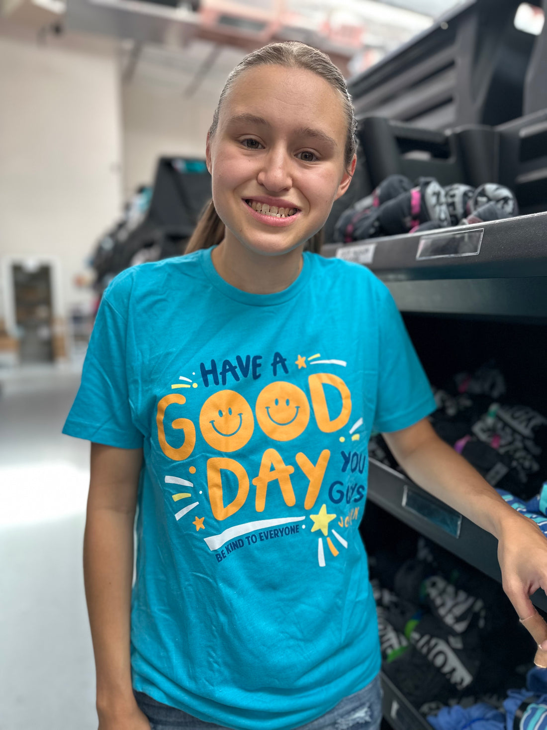 Jordyn, at the shirt shop, modeling a small in our Have A Good Day short-sleeved t-shirt.