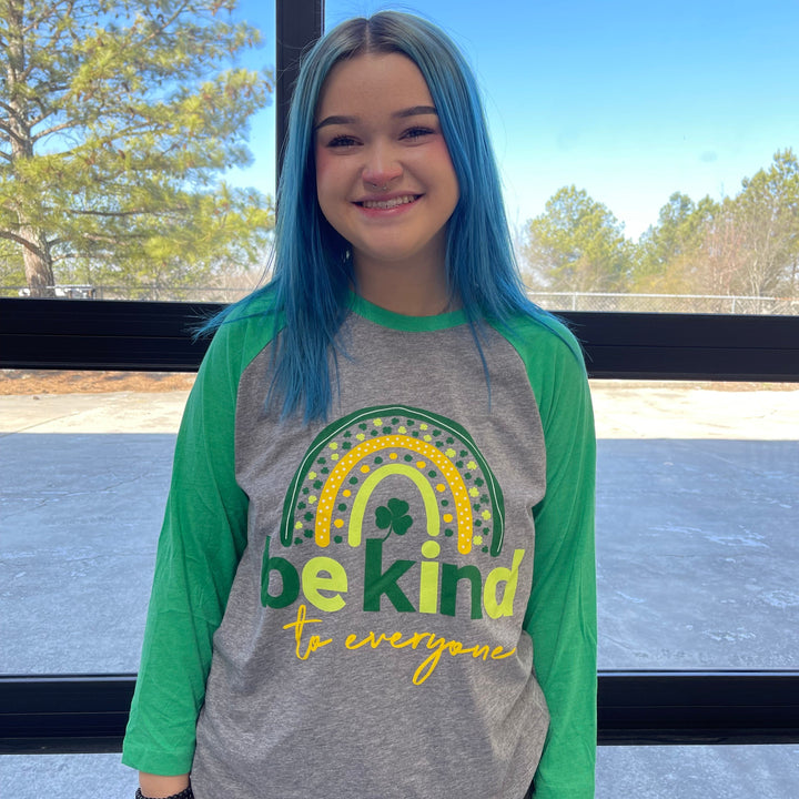 Adult St. Patrick's Day Be Kind to Everyone® Raglan with 3/4 length sleeves.  Sarah is wearing a medium in this photo.