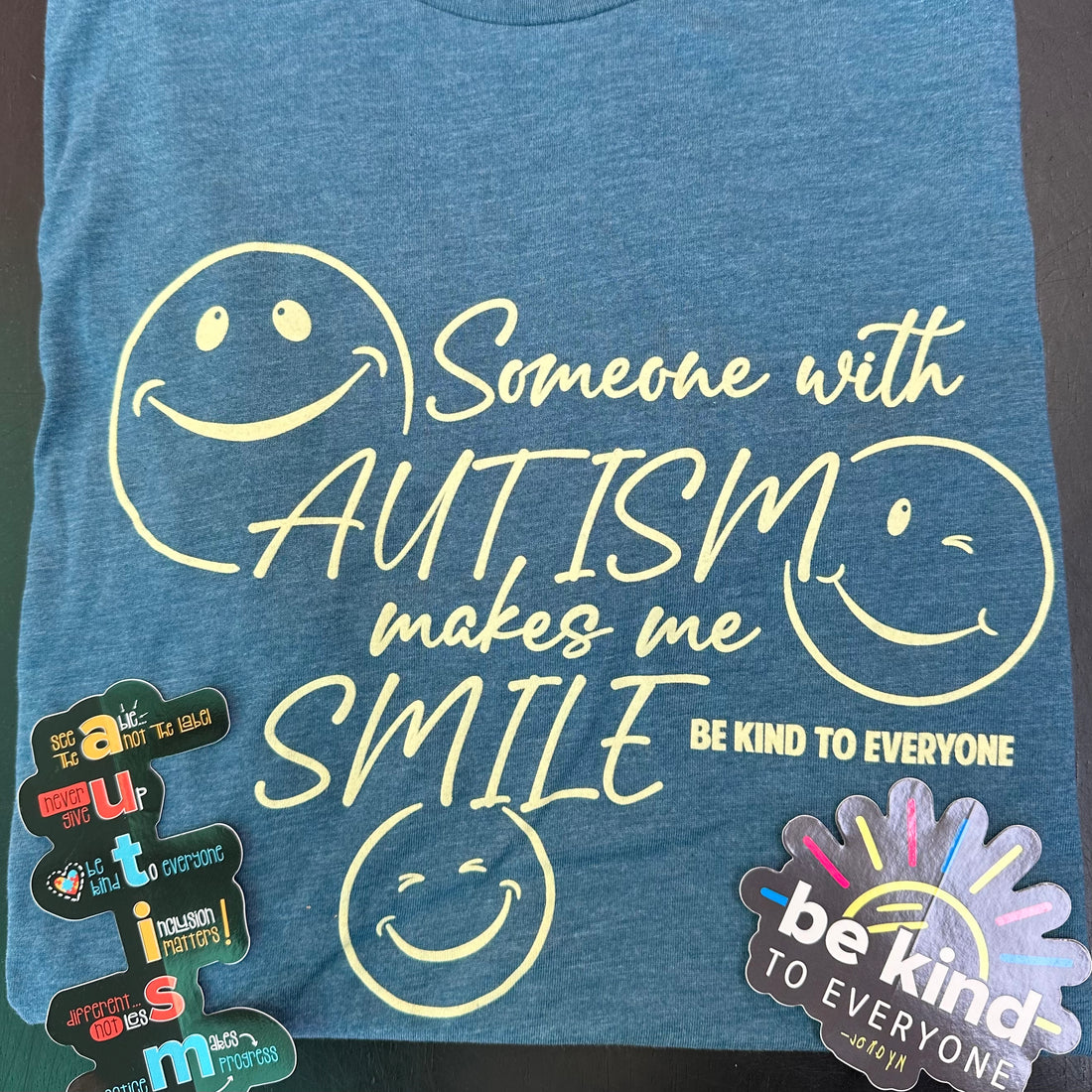 Autism Awareness Surprise Packs come with a short-sleeved t-shirt and two decals.  This is a photo of the heather deep teal t-shirt.