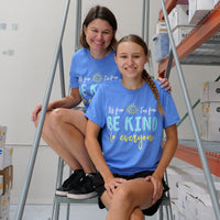 Jackie and Jordyn, in the shirt shop, wearing our It's Fine, I'm Fine, Be Kind to Everyone® short-sleeve t-shirts.