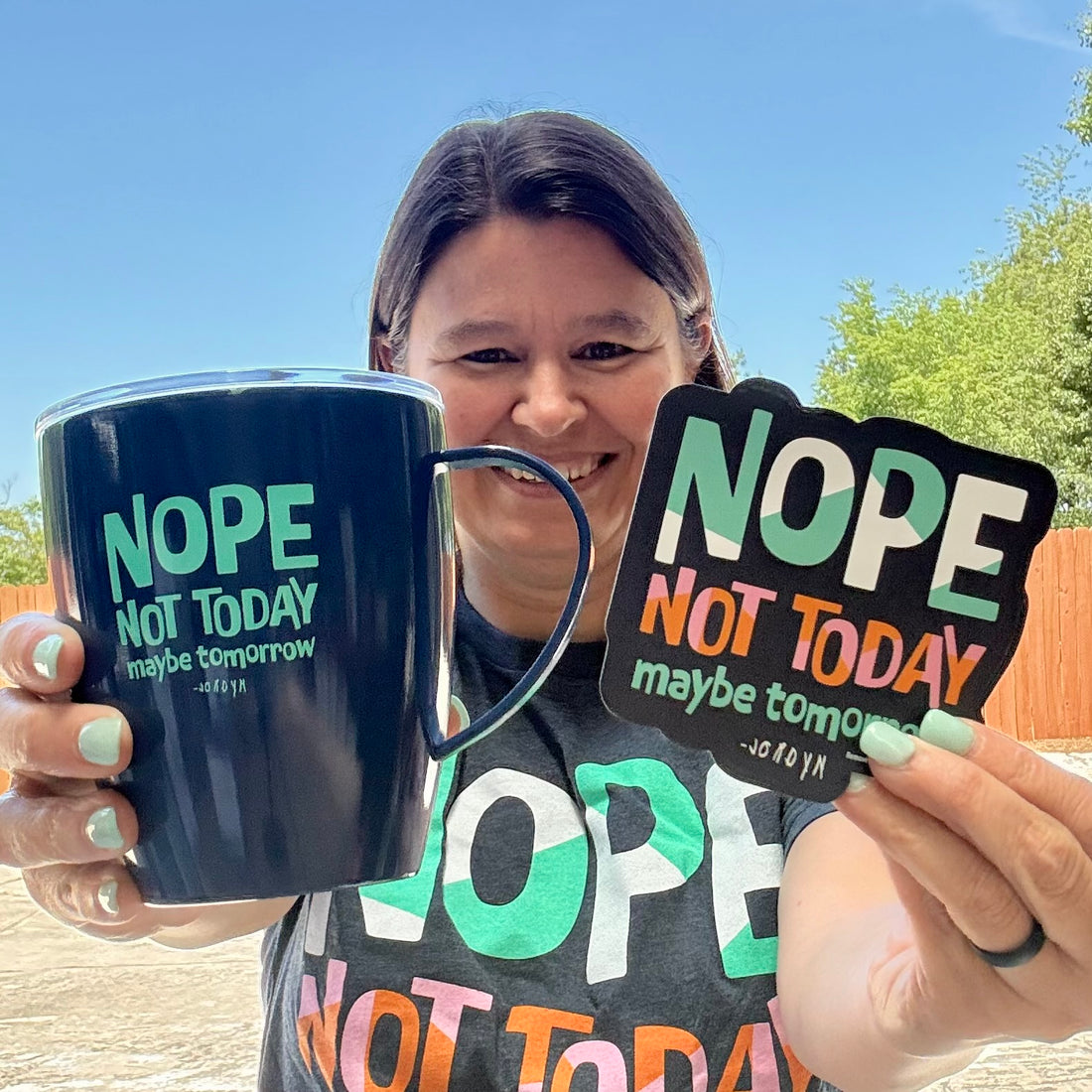 Jackie, holding our Nope Not Today Maybe Tomorrow Coffee Mug and Magnet, while outside.