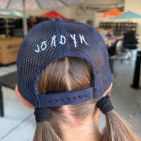 Jordyn, displaying her signature that is embroidered on the back of our Nope Not Today Maybe Tomorrow Trucker Hat.