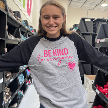 Jordyn, at the shirt shop, modeling a small in our Original Jordyn Be Kind to Everyone® Raglan T-shirt with 3/4-length sleeves.