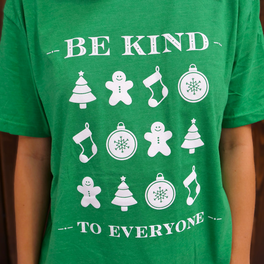 Zoomed in image of our Holiday Icons Be Kind to Everyone® short=sleeved t-shirt in green.  Jordyn is wearing a medium in this photo. 