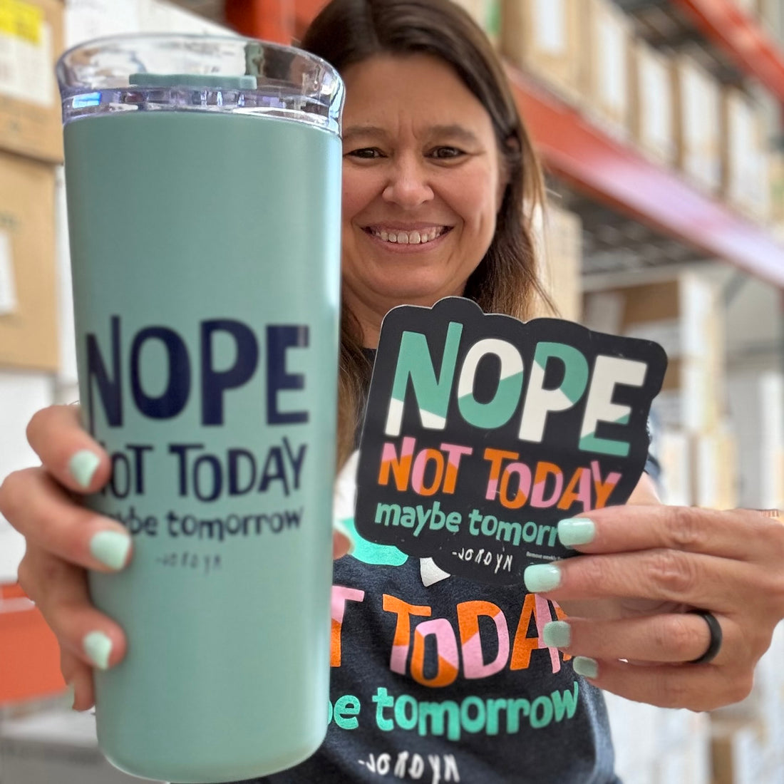Jackie, displaying our Nope Not Today tumbler and coordinating magnet, with the Shirt Shop in the background.