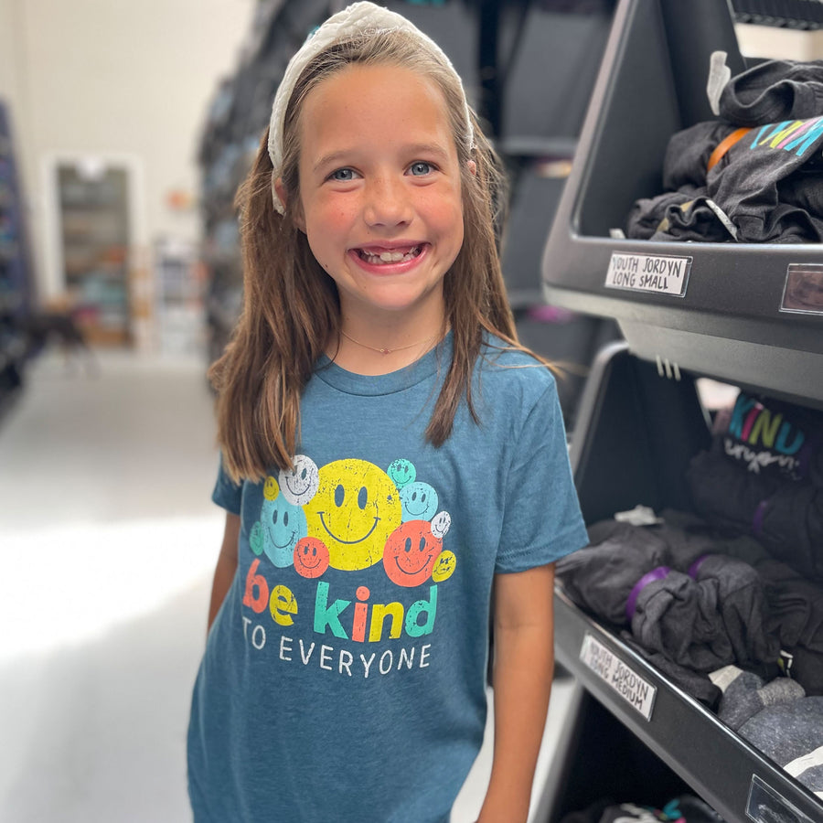 Katie, modeling a youth medium in our Smiley Be Kind to Everyone® short-sleeved t-shirt.
