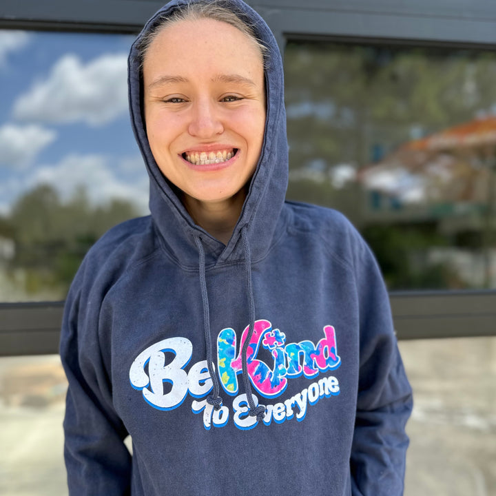 Jordyn, modeling a small, in our Tie-Dye-Filled Be Kind to Everyone® vintage-denim colored hoodie.