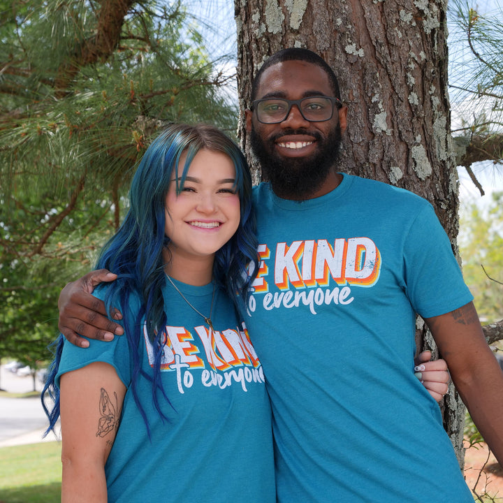 Sarah and Kei, wearing our 3D Be Kind to Everyone® short-sleeve tees. Sarah (left) is wearing a large. Kei (right) is wearing a small.