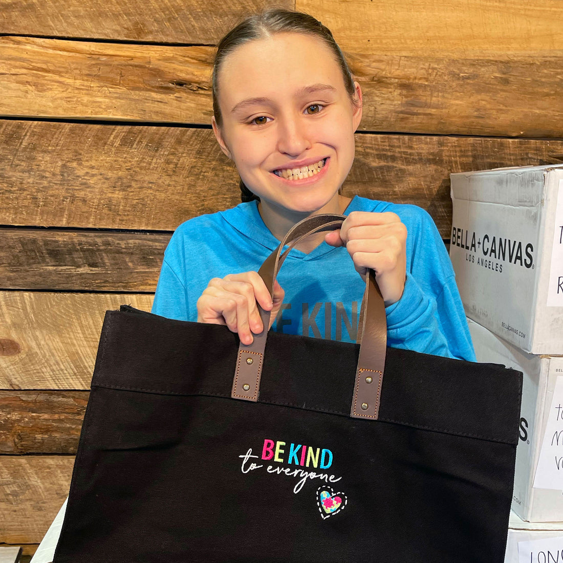 Jordyn holding a black Be Kind to Everyone tote bag in Jordyn&