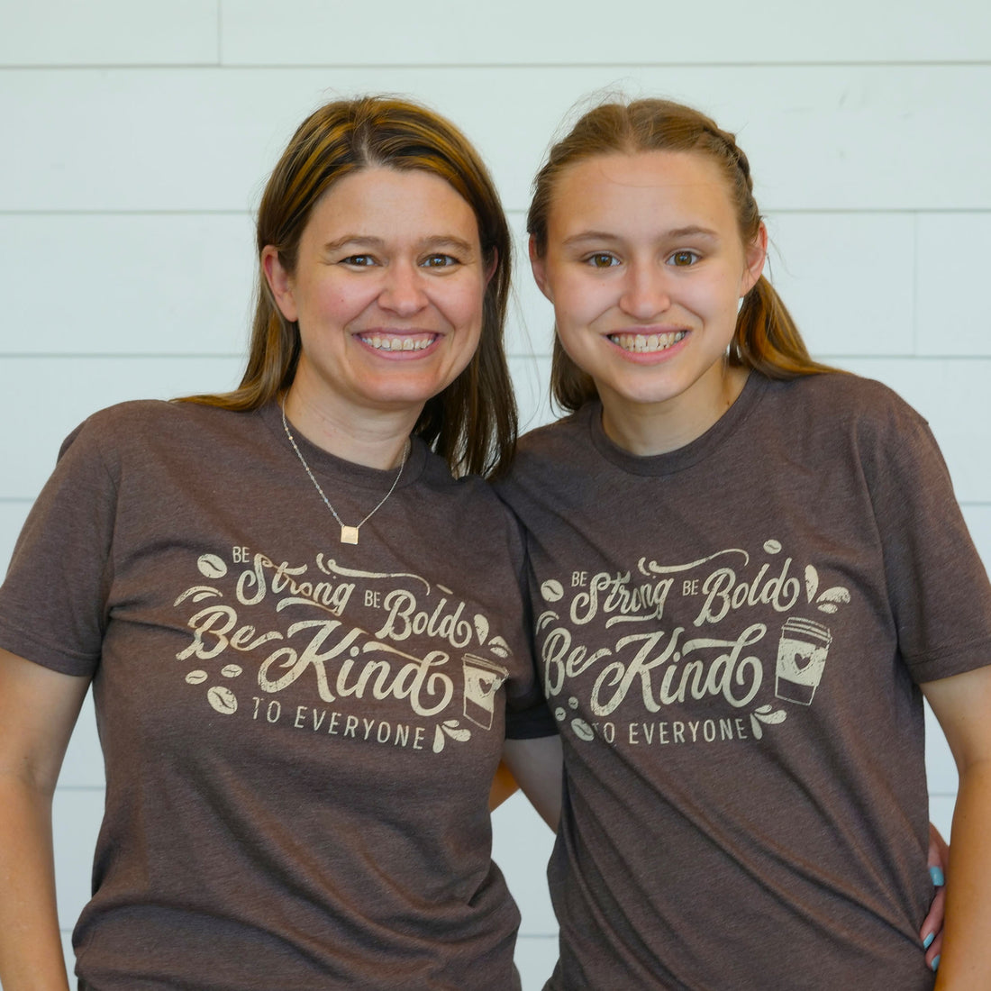 Jackie (left) and Jordyn (right) wearing our short-sleeve "Coffee" Be Kind to Everyone® shirt.  They are both wearing smalls in this photo.