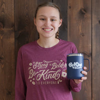 Jordyn wearing a small in our Coffee Be Kind to Everyone® long-sleeved t-shirt and holding one of our Be Kind to Everyone® mugs.