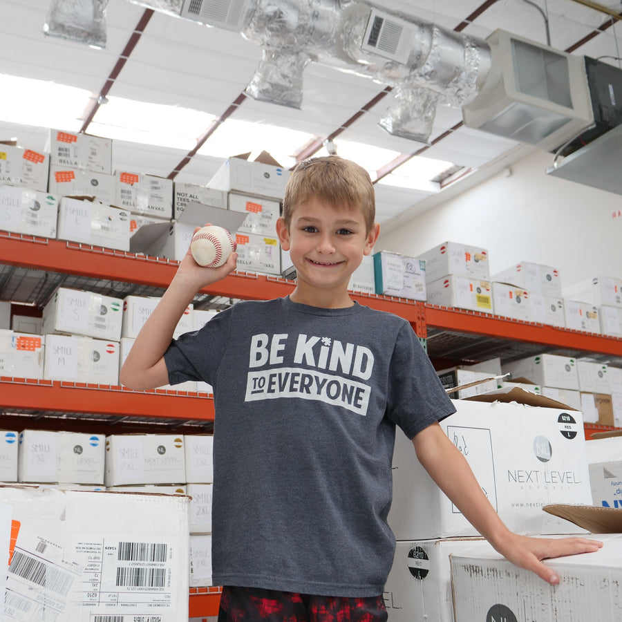 Hudson, at the shirt shop, modeling our gray Hudson Be Kind to Everyone® short-sleeved t-shirt.