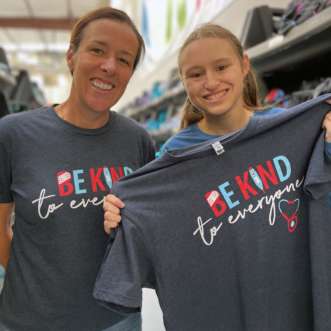 Jordyn and Julie showing our new Nurse Be Kind to Everyone® short-sleeve tees.  Julie is wearing a small in the photo.