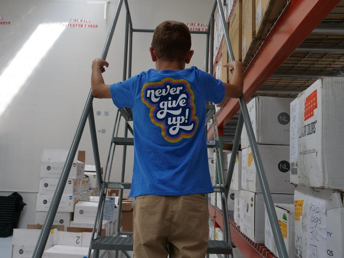 Back of our Never Give Up Be Kind to Everyone® short-sleeved youth t-shirt.