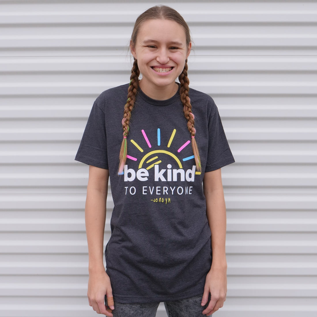 Jordyn is wearing our Sunshine Be Kind to Everyone® tee that features her signature.