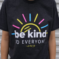 A close up image of our new Sunshine Be Kind to Everyone® tee that features Jordyn's signature.