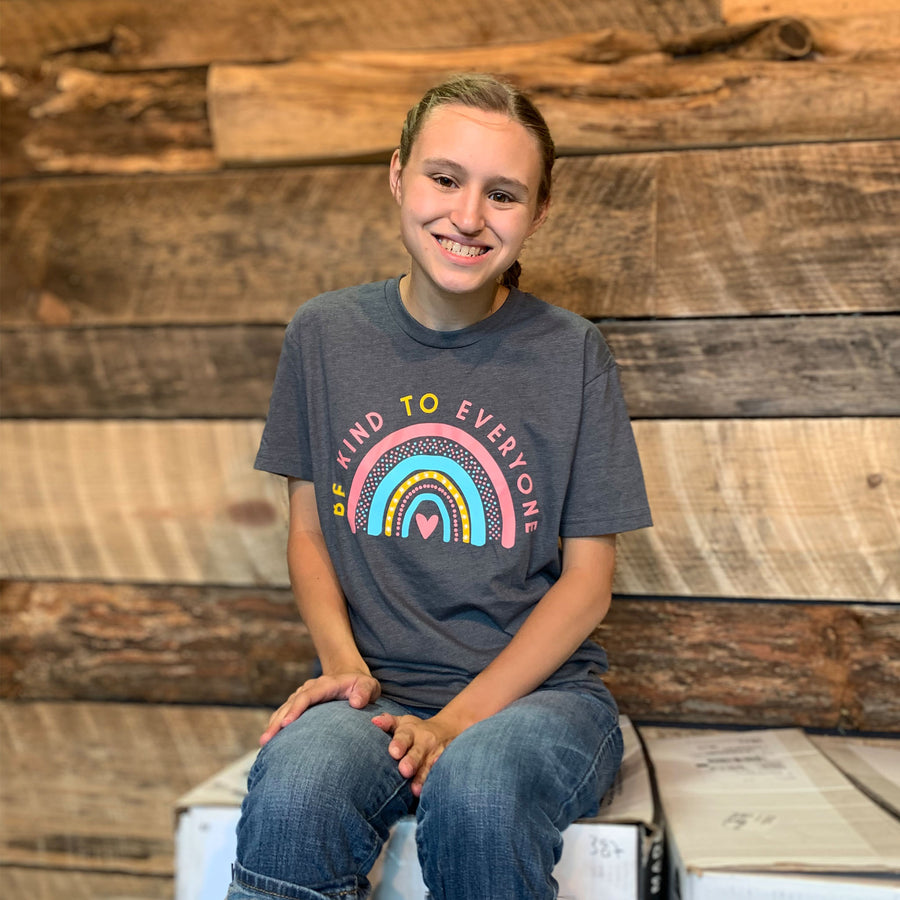 Zoomed out image of Jordyn wearing a small "Rainbow" Be Kind to Everyone® shirt.