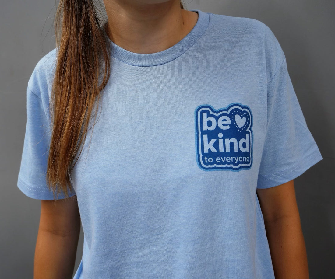Close up image of the front of our "Never Give Up" Be Kind to Everyone® short-sleeve tee.